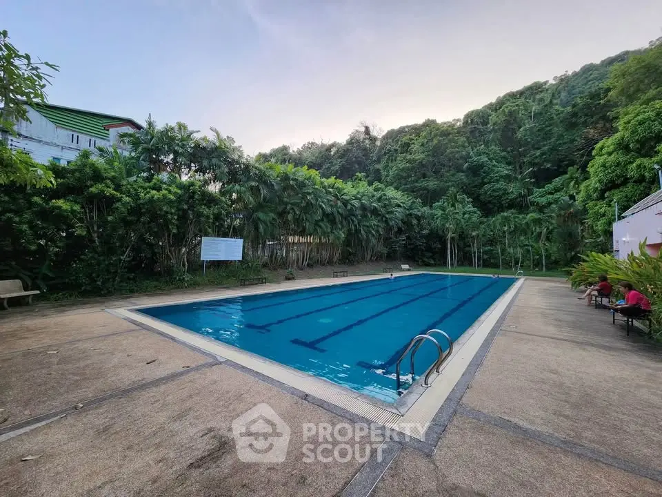Stunning outdoor swimming pool surrounded by lush greenery, perfect for relaxation and leisure.