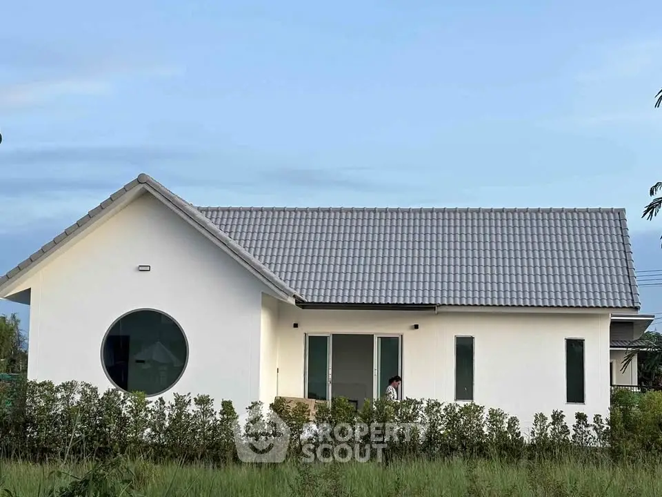 Charming single-story white house with modern design and lush greenery