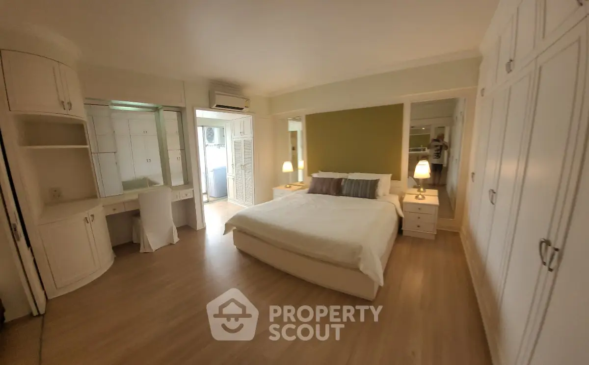 Spacious bedroom with elegant design and ample storage in a modern apartment.