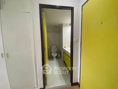 Compact bathroom with yellow accents and modern fixtures