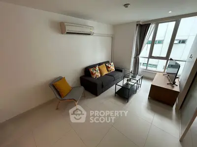 Modern living room with sleek furniture and large windows in a bright apartment.