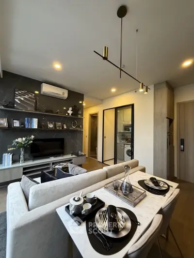 Modern living room with elegant decor and open layout, featuring stylish lighting and cozy dining area.