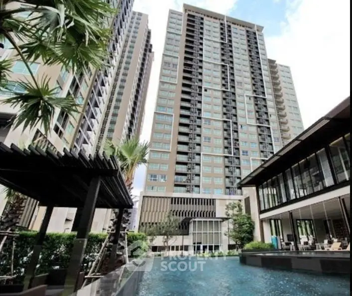 Luxurious modern high-rise buildings with lush greenery and pool area.