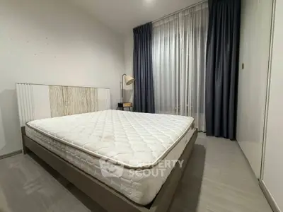 Spacious bedroom with modern decor and large window for natural light.