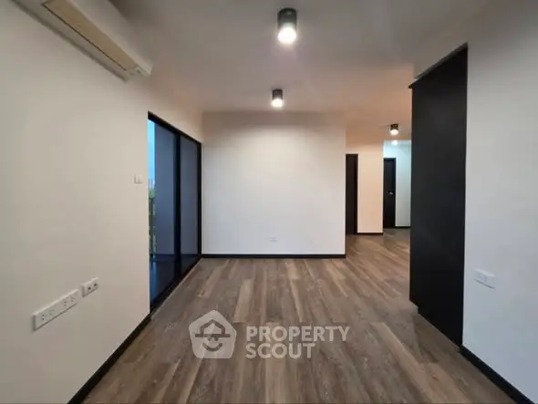 Spacious modern living room with wooden flooring and large windows