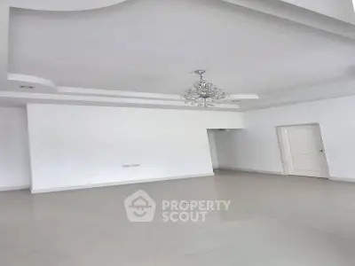 Spacious empty room with elegant chandelier and modern ceiling design