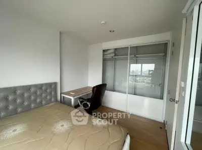 Modern bedroom with city view, featuring a stylish bed and workspace.