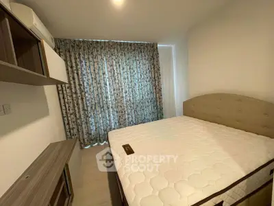 Cozy bedroom with large window and modern furnishings in a stylish apartment.