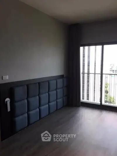 Spacious bedroom with modern design and large window offering city views.
