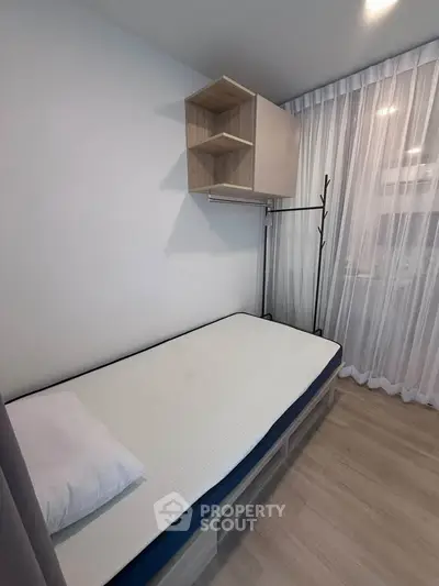 Cozy minimalist bedroom with single bed and modern storage solutions.