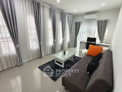 Spacious living room with modern decor and abundant natural light