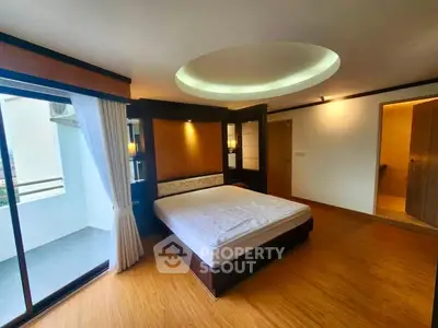 Spacious bedroom with modern design and balcony access in a luxury apartment.