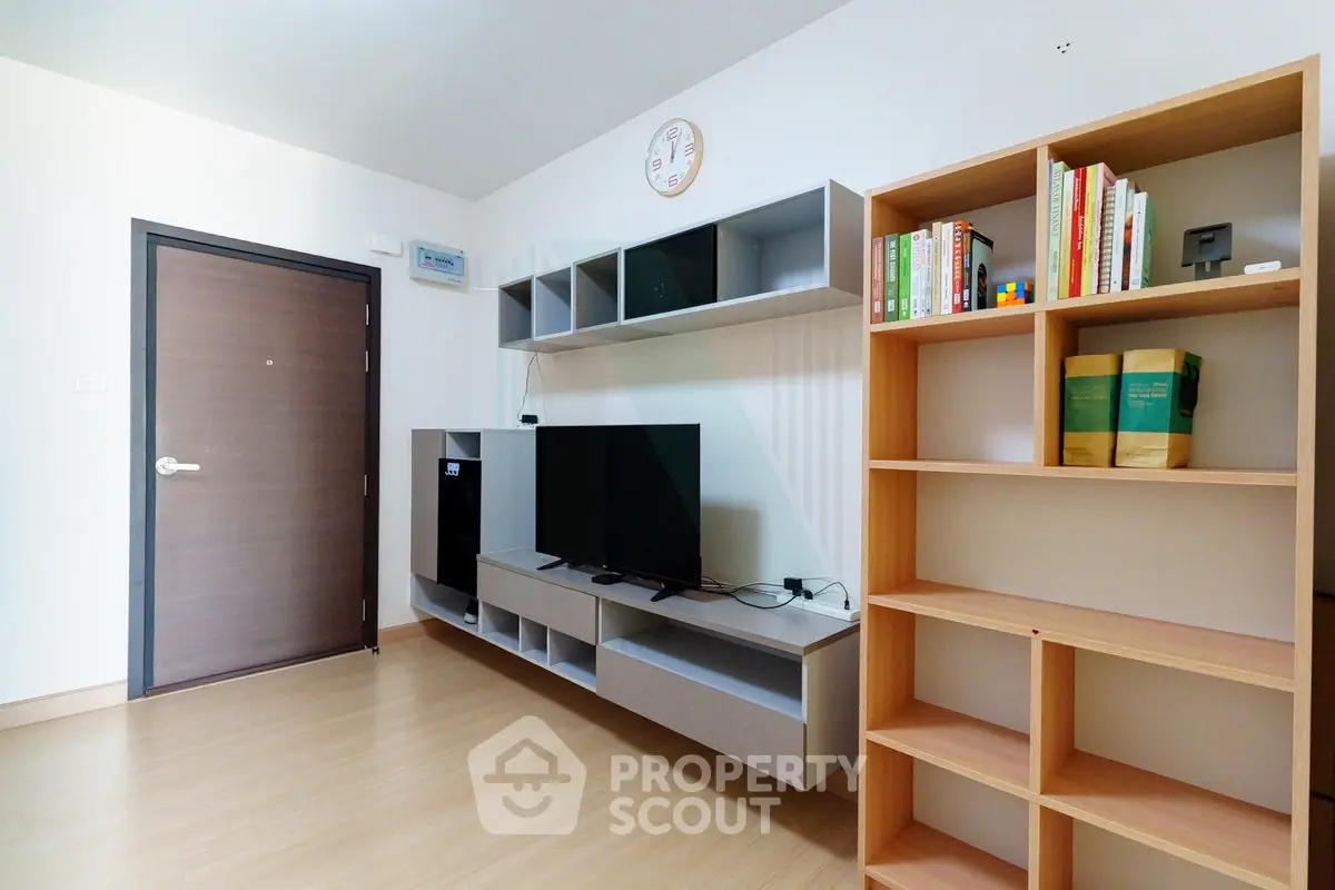 Modern living room with sleek TV unit and bookshelf, perfect for cozy relaxation.