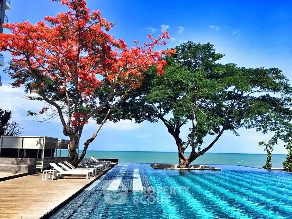 Stunning poolside view with vibrant trees and ocean backdrop, perfect for luxury living.