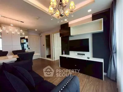 Modern living room with elegant chandelier and sleek black furniture