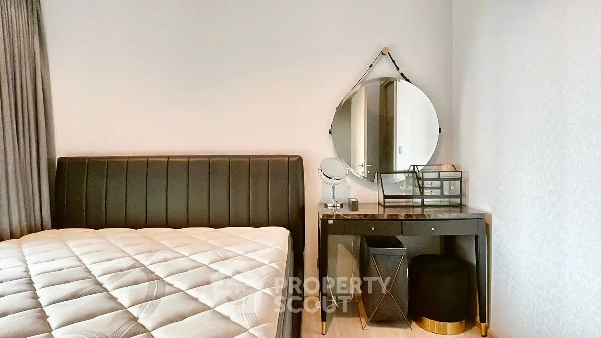 Stylish bedroom with modern decor and elegant furniture, featuring a sleek black bed and chic vanity table.