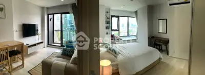 Modern apartment with spacious living room and bedroom, featuring large windows and city views.
