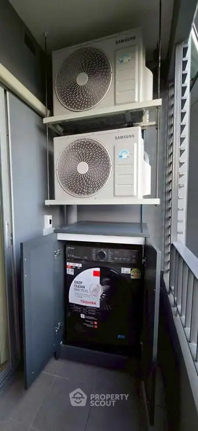 Modern balcony with air conditioning units and washing machine in sleek urban apartment.