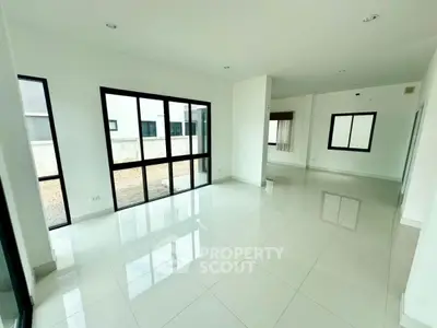 Spacious modern living room with large windows and glossy white tiles