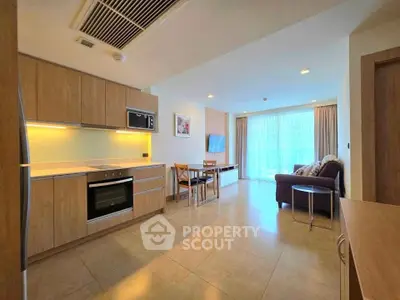 Modern open-layout kitchen and living room with natural light and stylish furnishings.