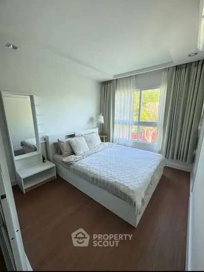 Bright and cozy bedroom with large window and modern decor