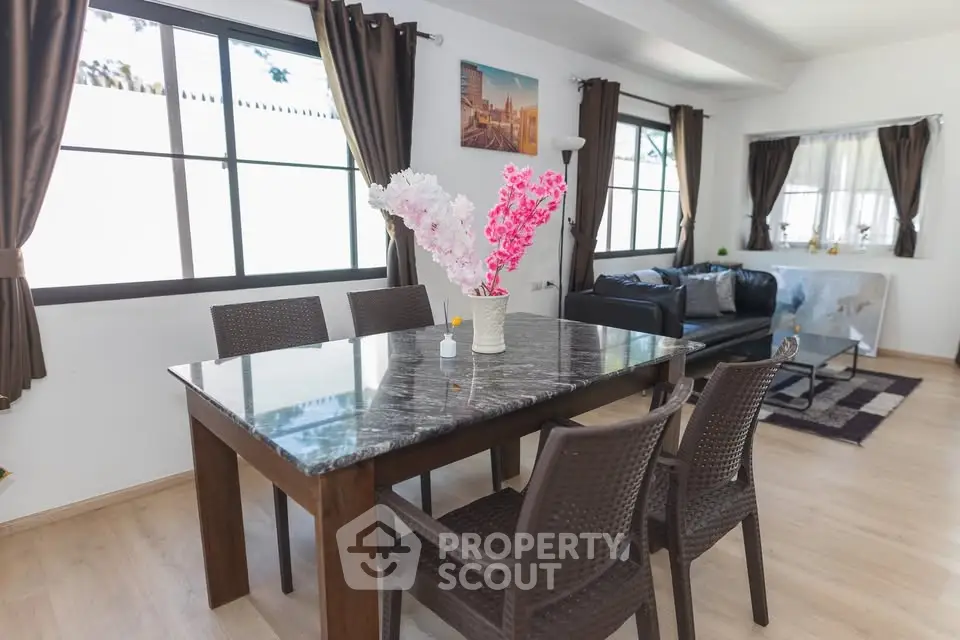 Spacious living room with elegant dining area and natural light