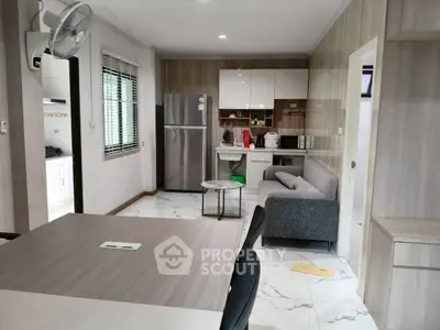 Modern open-layout kitchen and living area with sleek design and appliances.