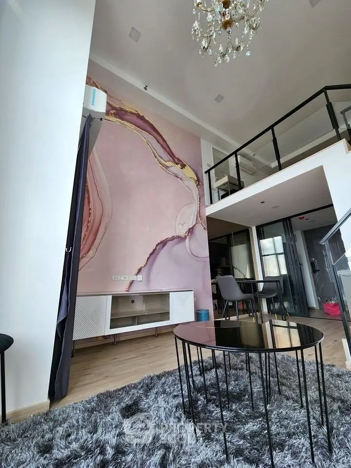 Modern loft apartment with high ceilings, elegant chandelier, and stylish decor.