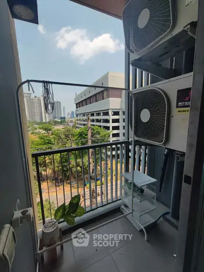 Urban balcony with air conditioning units and city view, perfect for compact outdoor space in high-rise living.