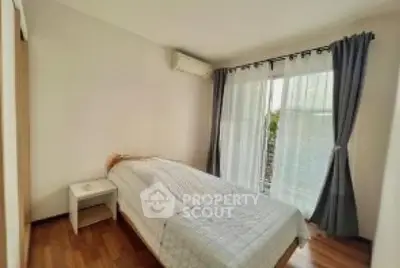 Cozy bedroom with natural light and wooden flooring