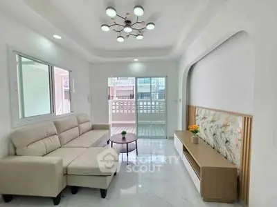 Spacious modern living room with elegant lighting and balcony access