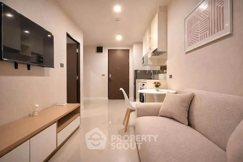 Modern living room with sleek design, wall-mounted TV, and cozy seating in a stylish apartment.