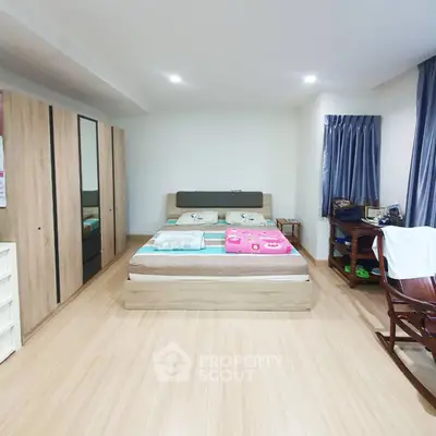 Spacious bedroom with modern wooden furniture and ample natural light