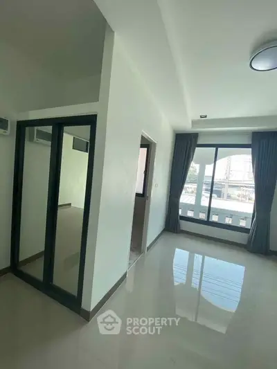 Spacious modern apartment with large windows and sleek flooring, offering abundant natural light and contemporary design.