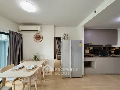 Modern open-layout kitchen with dining area and stainless steel fridge