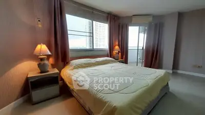Spacious bedroom with large windows and balcony access in modern apartment.