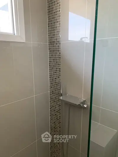 Modern bathroom with sleek shower design and stylish tile accents.