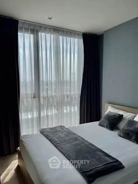 Modern bedroom with large window and stylish decor in urban apartment