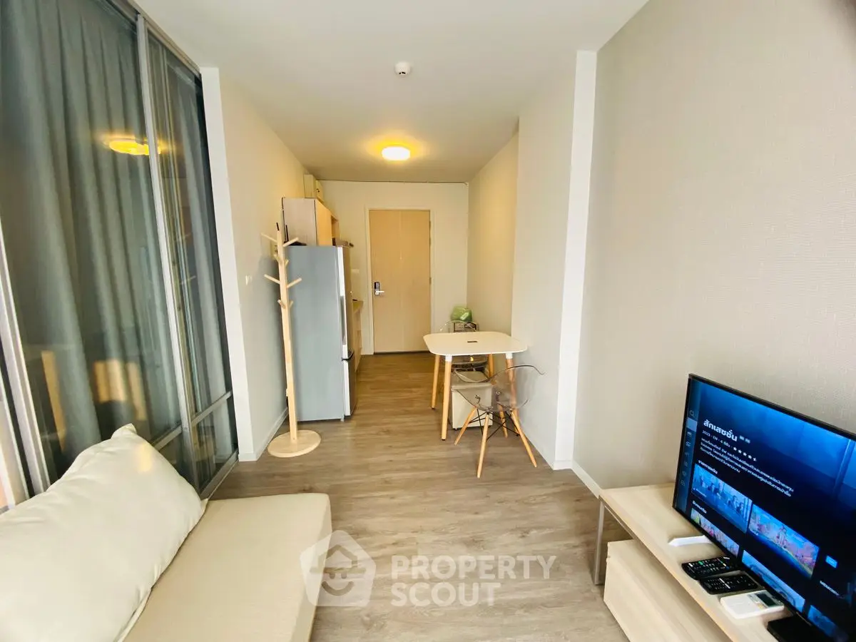 Modern living room with cozy sofa, TV, and dining area in a stylish apartment.