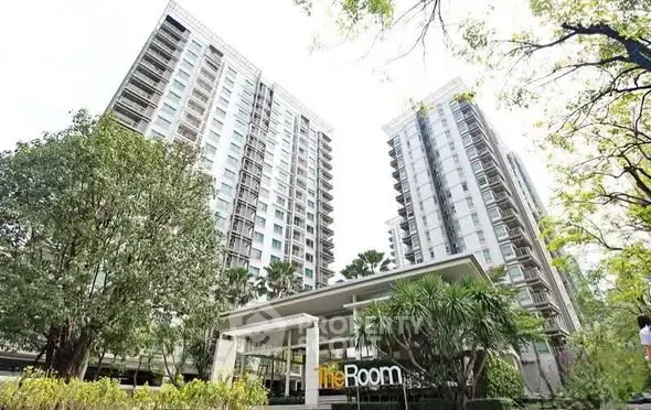 Modern high-rise residential building with lush greenery and elegant entrance