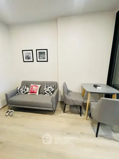 Modern living room with stylish gray sofa and dining area, perfect for cozy urban living.