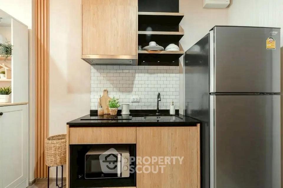 Modern kitchen with sleek appliances and stylish wooden cabinetry.