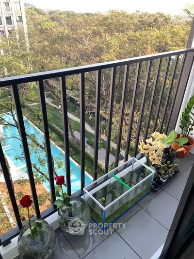 Charming balcony view with lush greenery and pool, perfect for relaxation and enjoying nature.
