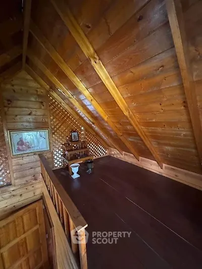 Charming wooden attic space with rustic decor and sloped ceiling