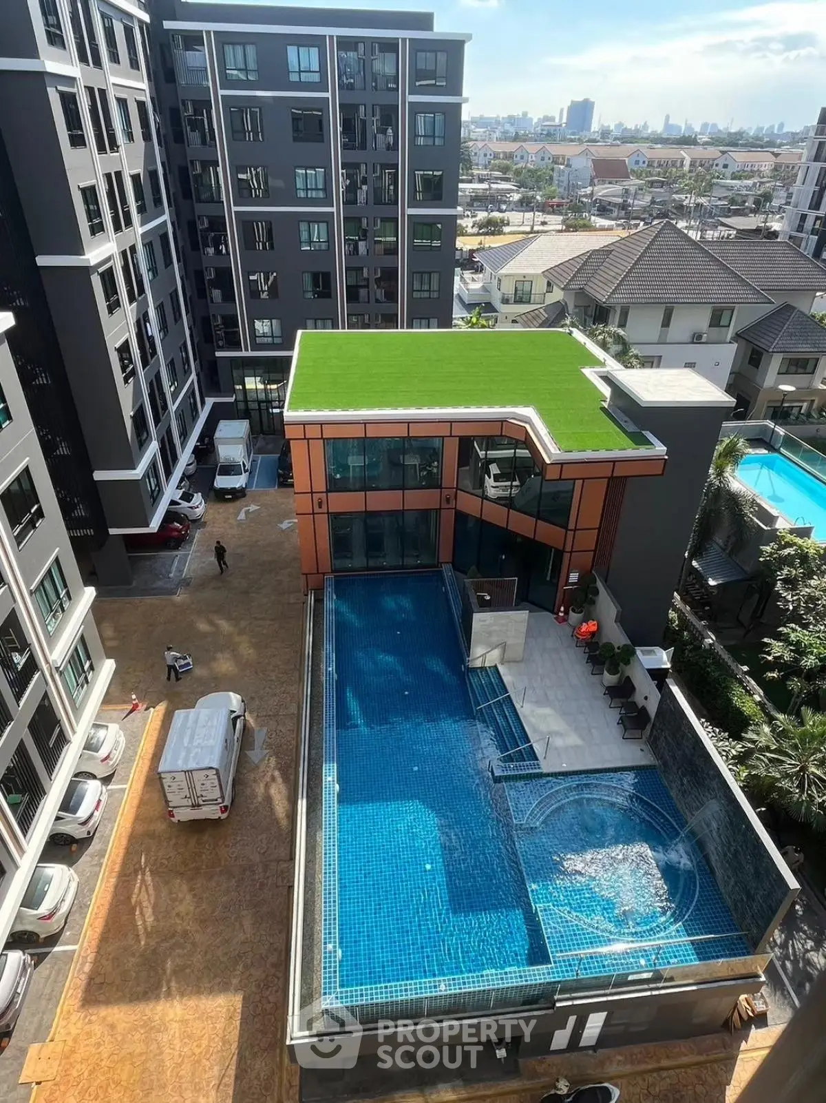 Modern apartment complex with rooftop garden and swimming pool in urban setting