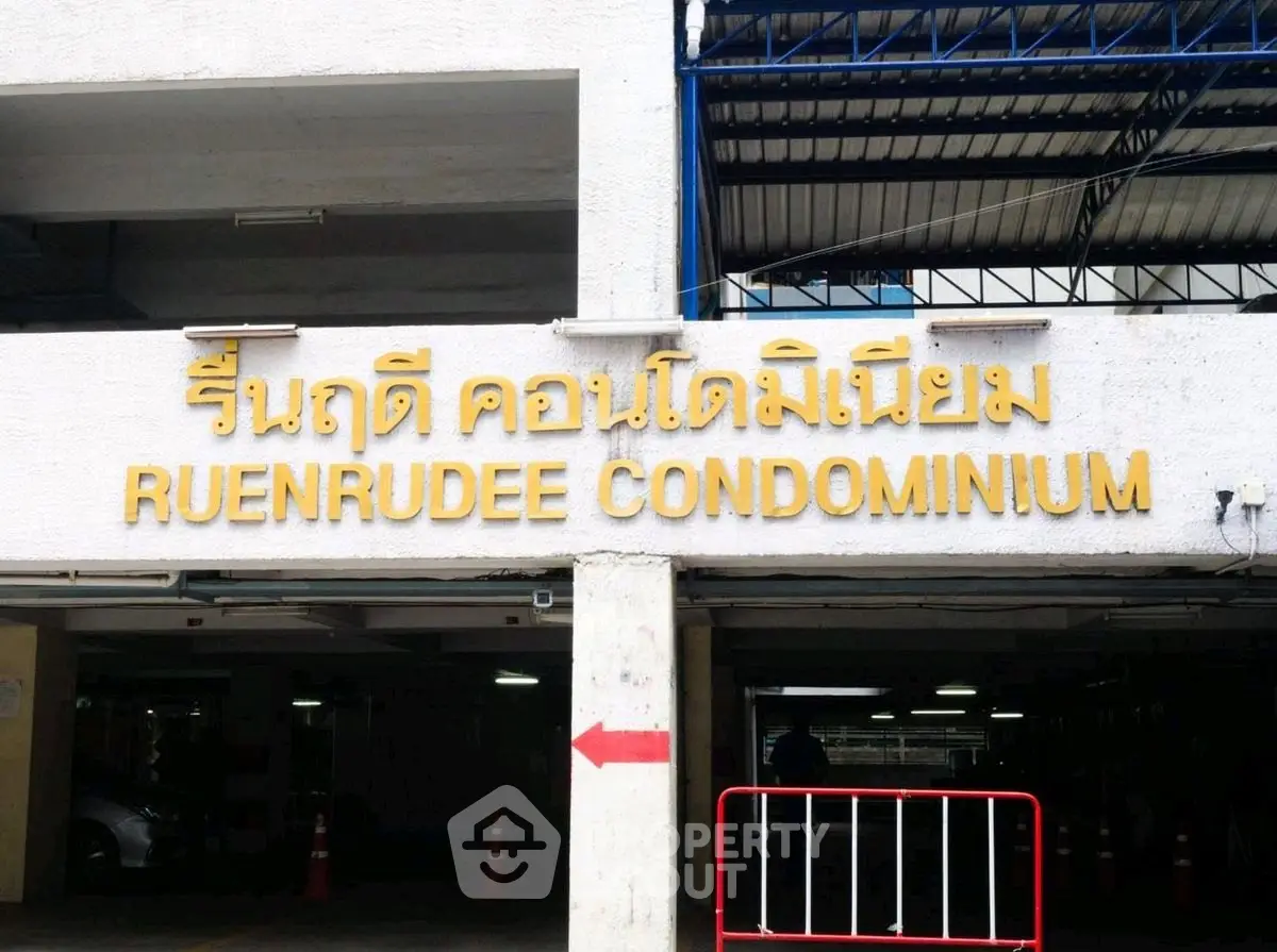 Entrance of Ruenrudee Condominium with parking area and signage.