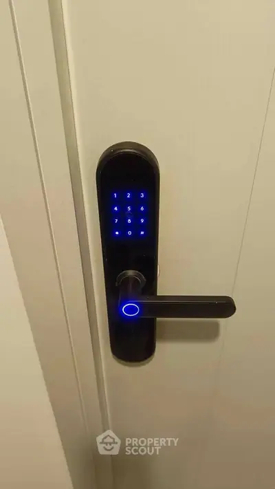 Modern digital door lock with keypad on white door, enhancing home security and style.