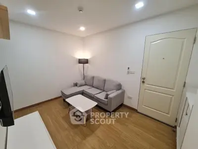 Cozy modern living room with wooden flooring and stylish gray sofa