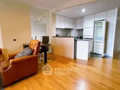 Modern open-plan kitchen and living area with wooden flooring and sleek appliances.