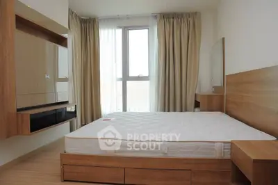 Modern bedroom with wooden furniture and large window, offering a cozy and inviting atmosphere.